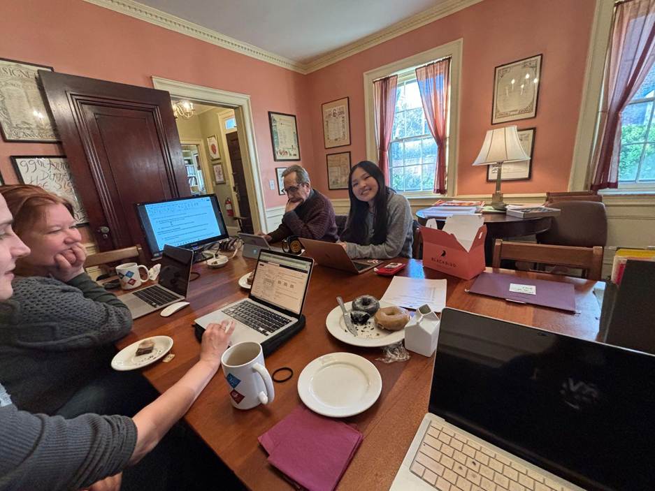 Gandi sitting at a table with Signet Staff members